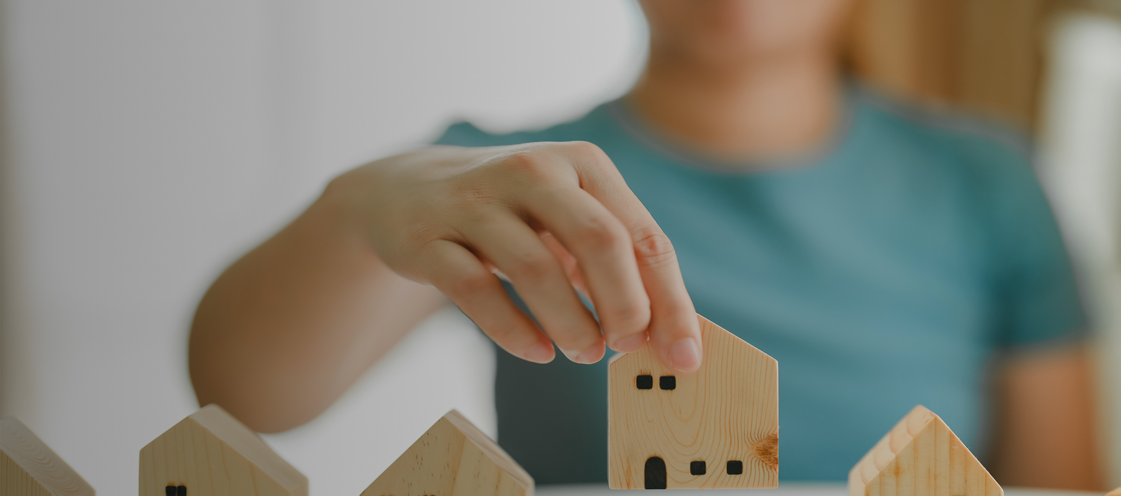 Person placing small wooden house