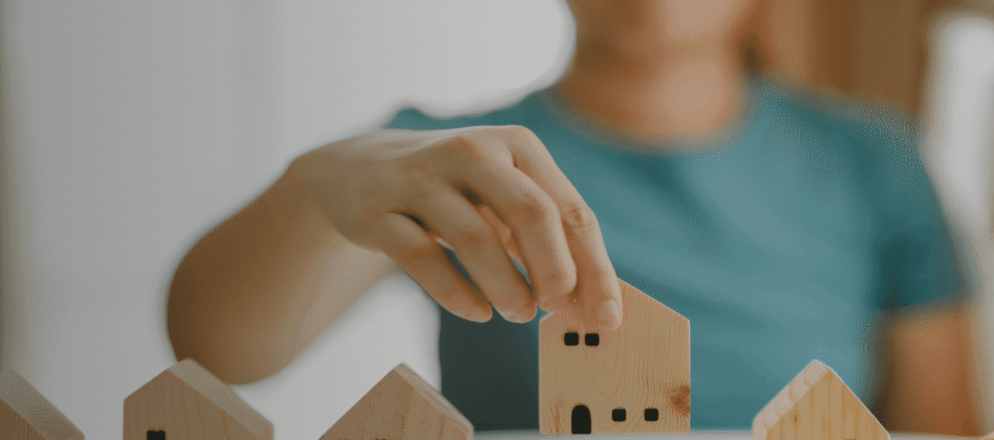 Person placing small wooden house